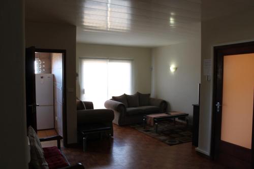 a living room with a couch and a refrigerator at The Timeless Way Self Catering Accommodation in Swakopmund