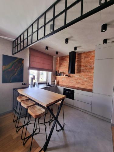 a kitchen with a wooden table and some chairs at Luksusowy Apartament Przy Sądzie Toruń in Toruń