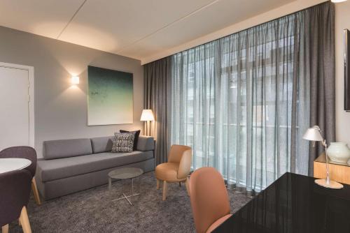 a living room with a couch and a table at Adina Apartment Hotel Copenhagen in Copenhagen