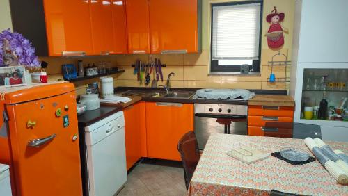 una cocina con armarios naranjas y una mesa. en Casa Vale en Silvi Marina