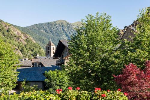 a group of trees with a church in the background at Hotel Coma in Ordino
