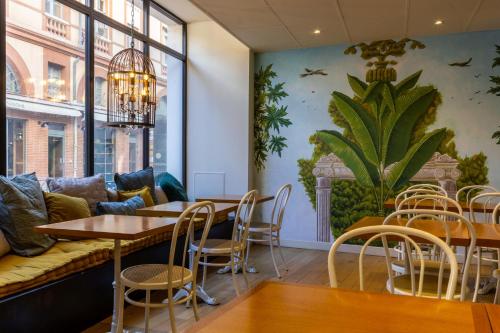 uma sala com uma mesa, cadeiras e um sofá em Hôtel de France em Toulouse