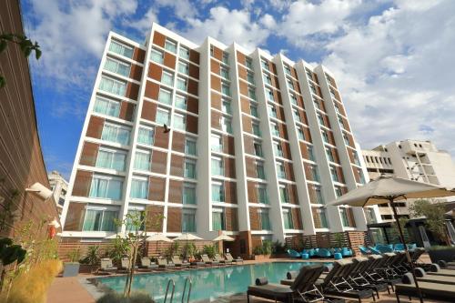 a large building with a swimming pool and chairs at Barceló Anfa Casablanca in Casablanca