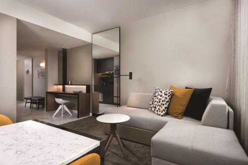 a living room with a couch and a table at Adina Apartment Hotel Frankfurt Westend in Frankfurt/Main