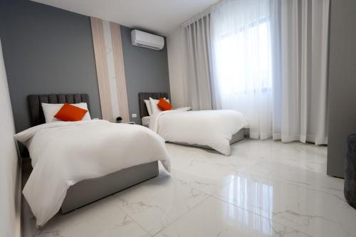 um quarto com 2 camas e uma grande janela em Al Kawther Hotel Apartments em Amã