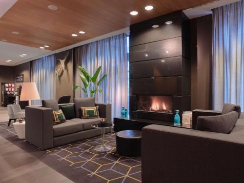 a living room with couches and a fireplace at Adina Apartment Hotel Berlin Hackescher Markt in Berlin