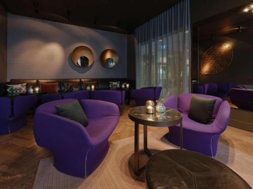 a lobby with purple chairs and a table at Adina Apartment Hotel Berlin Hackescher Markt in Berlin