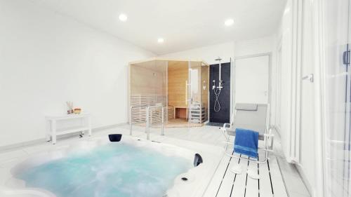 una vasca da bagno in una camera bianca con sedia di Il Giardino Di Rebecca a Ferrara