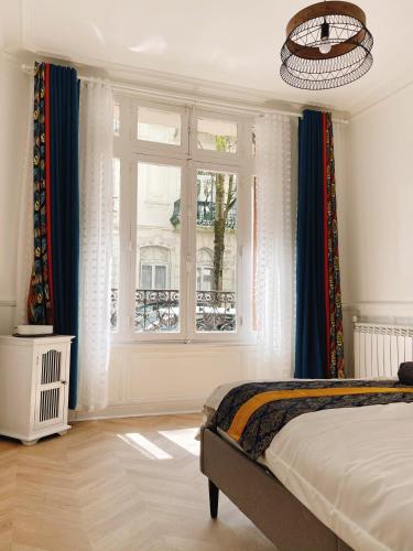 une chambre avec un lit et une fenêtre dans l'établissement Villa muguette - coeur de Vichy- RDC-véranda sur la terrasse, à Vichy