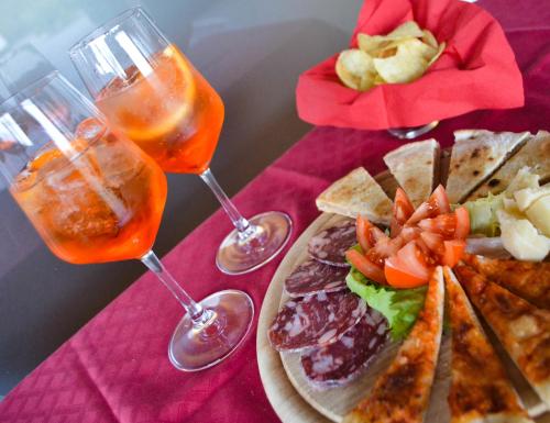 a table with two wine glasses and a plate of food at Hotel Don Carlo in Broni