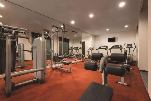 a gym with several tread machines in a room at Adina Apartment Hotel Berlin Mitte in Berlin