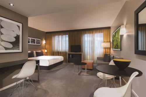 a hotel room with a bed and a table and chairs at Adina Apartment Hotel Berlin Mitte in Berlin