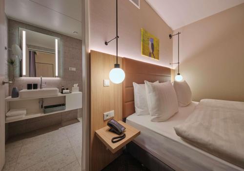 a hotel room with a bed and a sink at Adina Apartment Hotel Cologne in Cologne