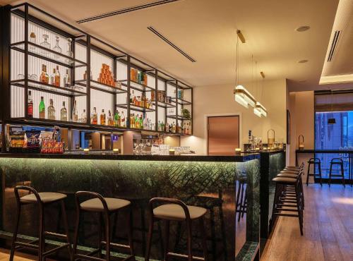 a bar in a restaurant with stools at Adina Apartment Hotel Cologne in Cologne