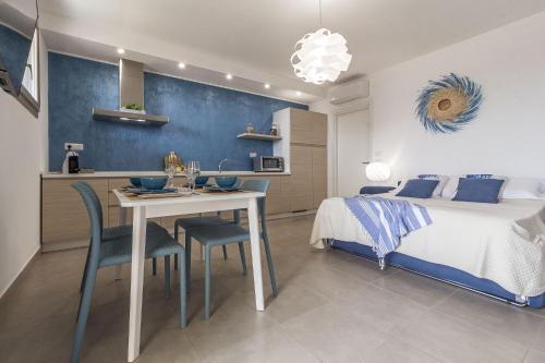 a bedroom with a bed and a table and chairs at Skyfive Water Apartment in Alghero
