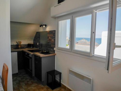 - une cuisine avec fenêtres et vue sur l'océan dans l'établissement Bel appartement refait à neuf, proche commerces et plage - FR-1-418-175, au Palais