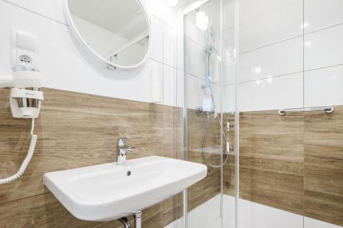 a bathroom with a white sink and a mirror at VacationClub - Boulevard Residence Apartament 11 in Ustronie Morskie