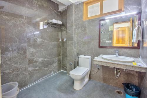 a bathroom with a toilet and a sink at Thrill Nature Cottage in Manāli