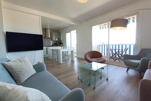 un salon avec un canapé bleu et une table dans l'établissement Spacious and bright cocoon near the sea, à Bandol