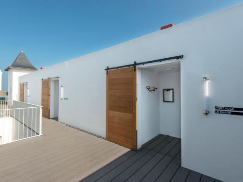 Cette chambre dispose d'une terrasse avec une porte en bois. dans l'établissement Studio moderne à Sauzon avec vue port, wifi et lits faits - FR-1-418-186, à Sauzon