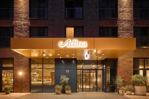 Adina Apartment Hotel Dusseldorf في دوسلدورف: مبنى مكتب مع علامة atmine على الواجهة