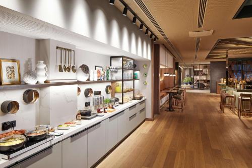 杜塞尔多夫Adina Apartment Hotel Dusseldorf的厨房配有白色橱柜和食品柜台