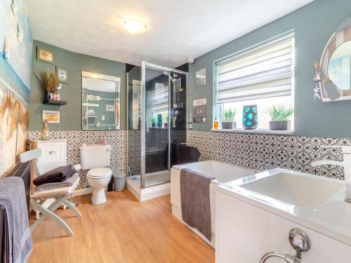 a bathroom with a tub and a toilet at The Innkeep in Watlington