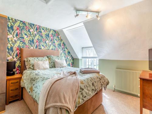a bedroom with a bed with a floral wallpaper at The Innkeep in Watlington