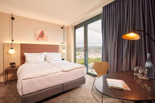 um quarto de hotel com uma cama e uma mesa em Adina Apartment Hotel Stuttgart em Stuttgart