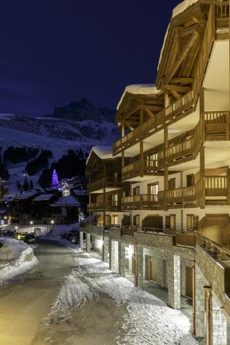 a ski lodge in the snow at night at CGH Résidence Boutique La Grange aux Fées in Valmorel