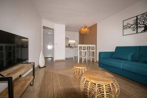 un salon avec un canapé bleu et une table dans l'établissement Nice quiet nest near Fréjus Plage and Port Fréjus, à Fréjus