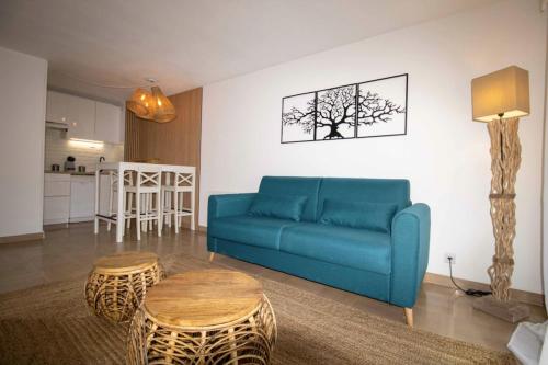 ein Wohnzimmer mit einem blauen Sofa und einem Tisch in der Unterkunft Nice quiet nest near Fréjus Plage and Port Fréjus in Fréjus