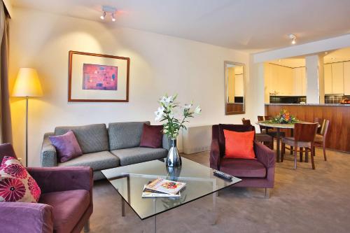 a living room with a couch and chairs and a table at Adina Apartment Hotel Budapest in Budapest