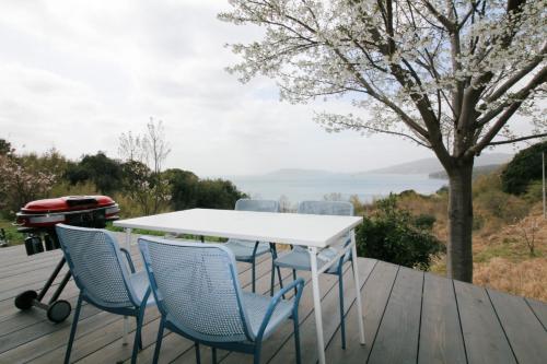 長門市にある1日1組限定貸切宿 Kitohana YUYAのテーブルと椅子が備わるデッキから水辺の景色を望めます。