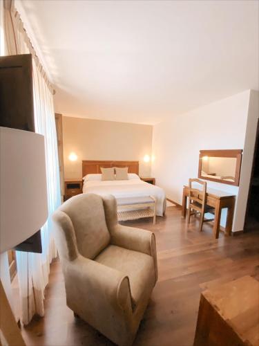 a bedroom with a bed and a couch and a chair at Hotel Rural Candela y Plata in Puerto de Béjar