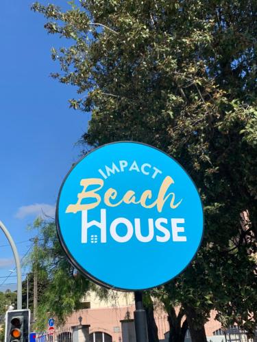 a sign for a beach house on a street at Impact Beach House in Estoril