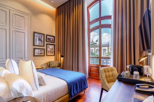 a hotel room with a bed and a desk and a window at Boutique Hotel Cordial Plaza Mayor de Santa Ana in Las Palmas de Gran Canaria