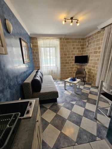 Una sala de estar con un sofá y un televisor. en Lanterna Apartments, en Kotor