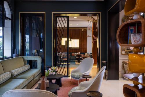 a living room with a couch and chairs at Hotel Montalembert in Paris