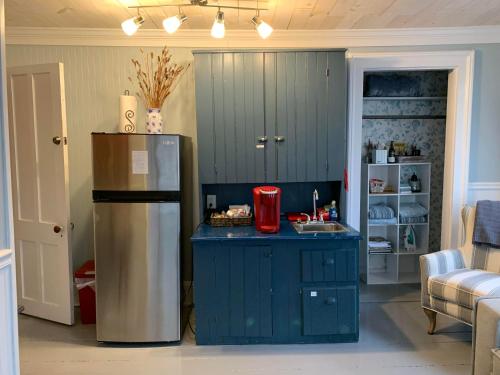 uma cozinha com uma ilha azul e um frigorífico em Wind in the Willows Overnight em Jefferson