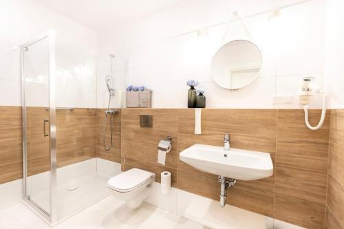 a bathroom with a toilet and a sink and a shower at VacationClub - Boulevard Residence Apartament 22 in Ustronie Morskie
