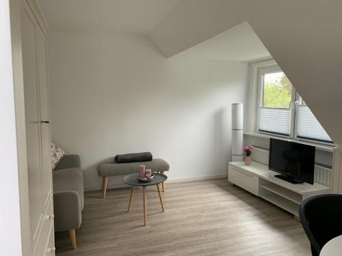 un soggiorno bianco con un divano e una TV di Hus Dungrot a Sankt Peter-Ording