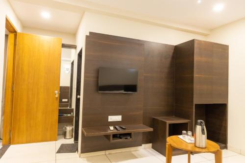 a living room with a tv and a table in a room at HOTEL THE GRAND DIPAK in Junagadh