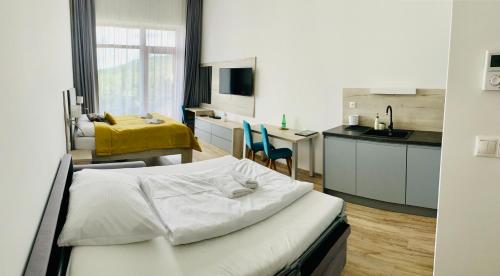 a bedroom with a bed and a kitchen with a sink at Apartmány Tatry in Smokovce