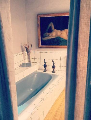a bathroom with a sink with a woman in a painting at LE LIT DE LA SEMOY Chassepierre in Chassepierre