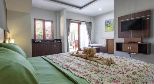 un osito de peluche tirado en una cama en un dormitorio en RS Beautiful Villa Sanur, en Denpasar