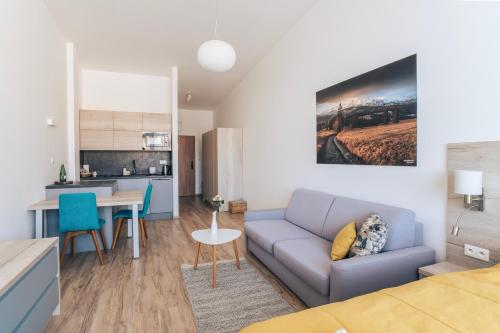 a living room and kitchen with a couch and a table at Apartmány Tatry in Smokovce