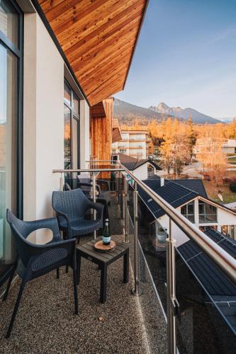 a balcony of a house with chairs and a table at Apartmány Tatry in Smokovce
