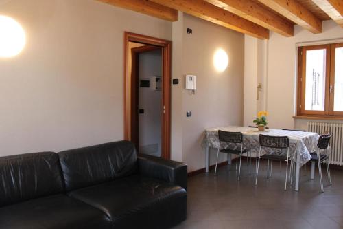- un salon avec un canapé et une table avec des chaises dans l'établissement Alex's lake house, à Riva di Solto