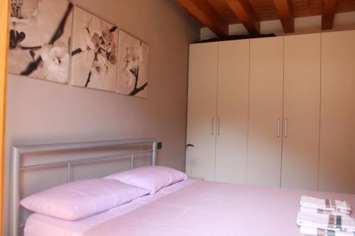 a bedroom with a bed with white cabinets at Alex's lake house in Riva di Solto